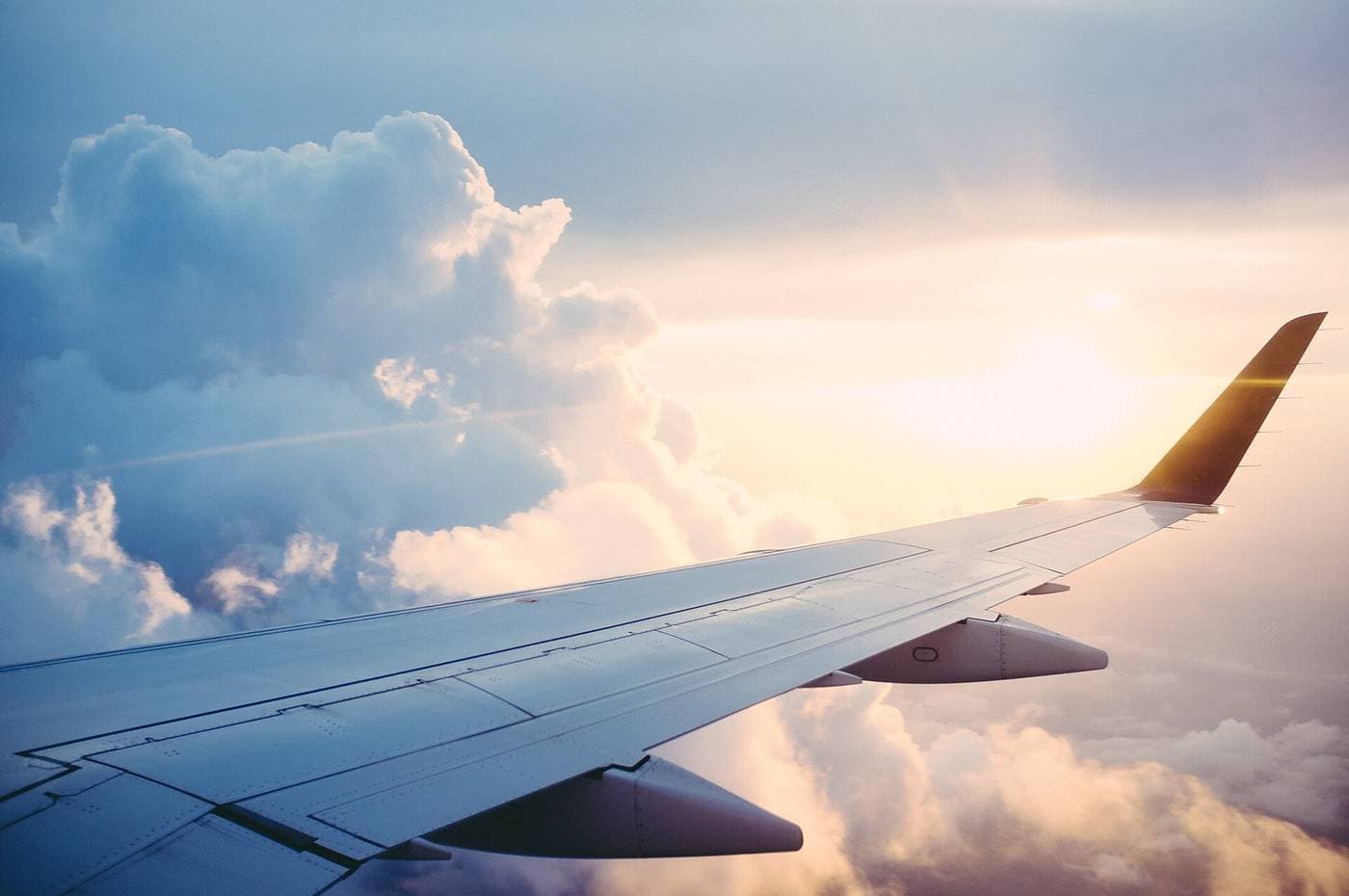 Aile d'un avion de ligne au-dessus des nuages, dans la lumière du soleil